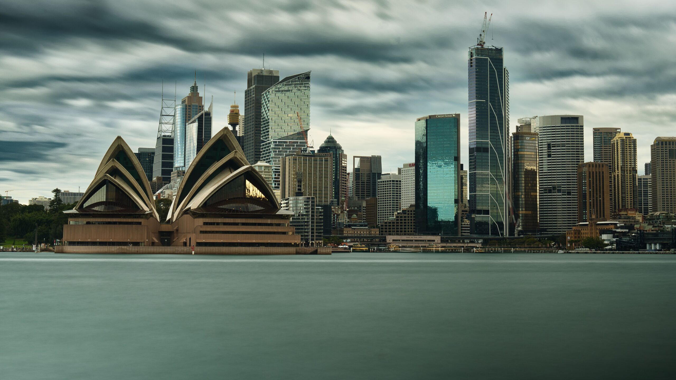 Panoramic view of Sydney's iconic skyline featuring the Sydney Opera House and towering skyscrapers.